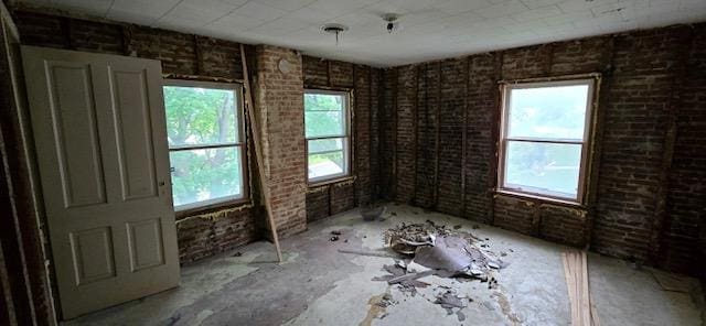 empty room featuring brick wall