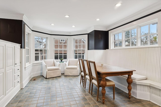 dining space featuring ornamental molding, tile patterned flooring, and a wealth of natural light