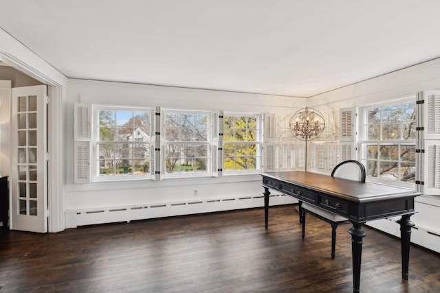 office space with a notable chandelier, a healthy amount of sunlight, dark hardwood / wood-style flooring, and a baseboard heating unit