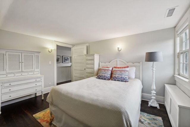 bedroom with dark hardwood / wood-style flooring