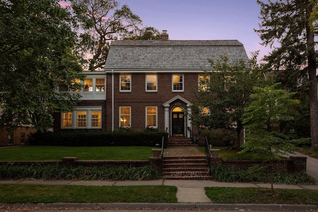 colonial inspired home with a lawn