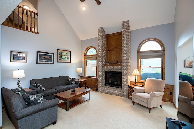 living room featuring ceiling fan, high vaulted ceiling, and a brick fireplace