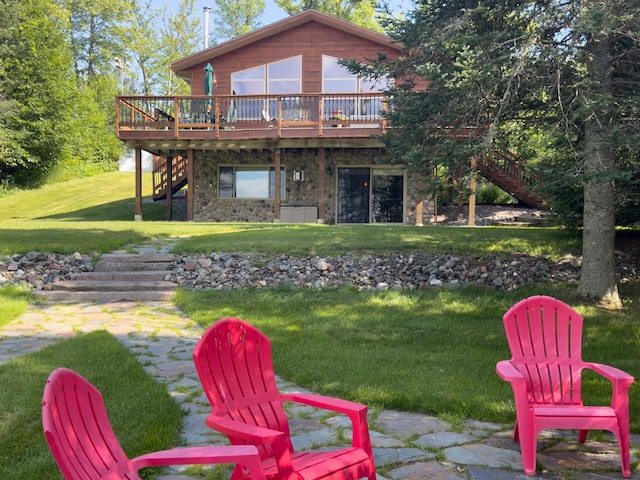 back of house with a lawn, stairs, stone siding, and a deck