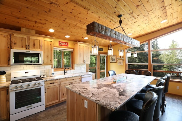kitchen with tasteful backsplash, white appliances, a center island, a sink, and wood ceiling