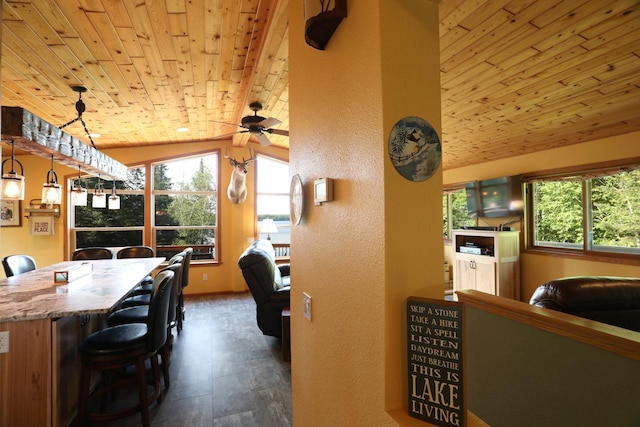 dining room with a ceiling fan, wood ceiling, a textured wall, and lofted ceiling