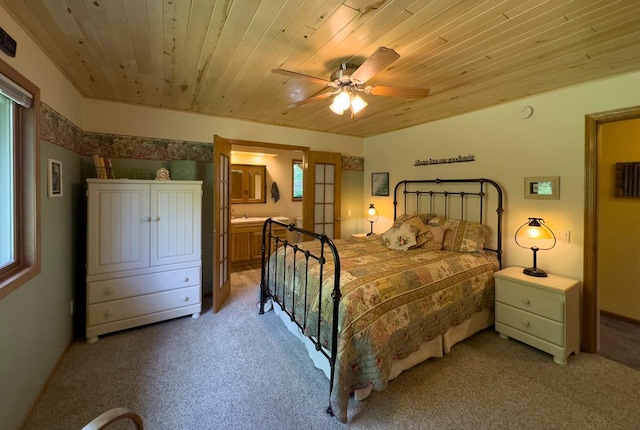 bedroom with connected bathroom, light colored carpet, wooden ceiling, and ceiling fan