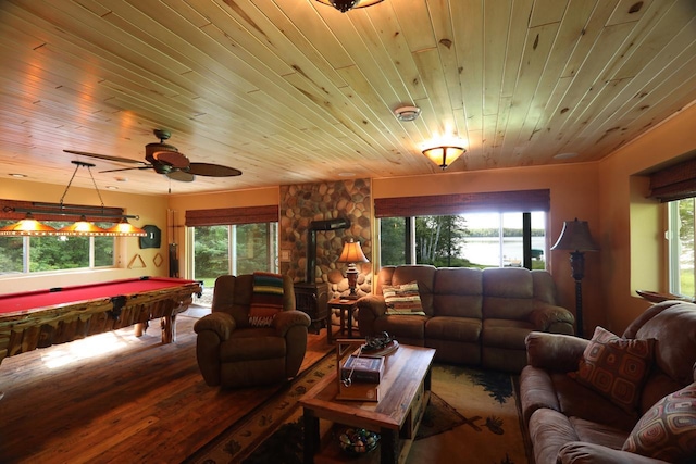 living area with ceiling fan, wood finished floors, billiards, a wood stove, and wooden ceiling