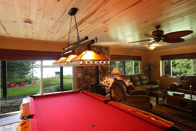 rec room with wood ceiling, pool table, ceiling fan, and a wood stove
