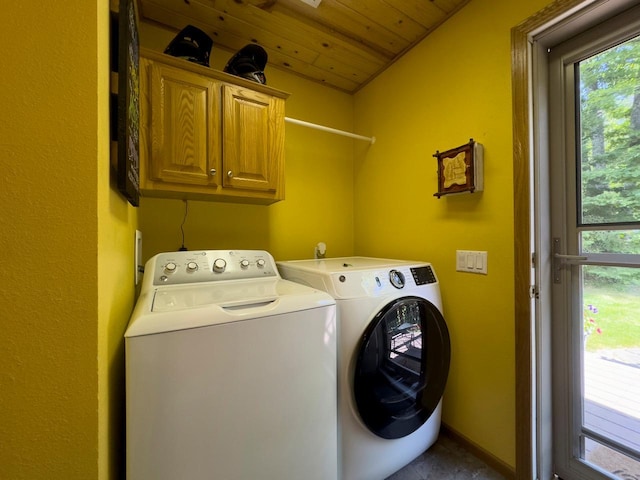 clothes washing area with washing machine and clothes dryer, cabinet space, wood ceiling, and plenty of natural light