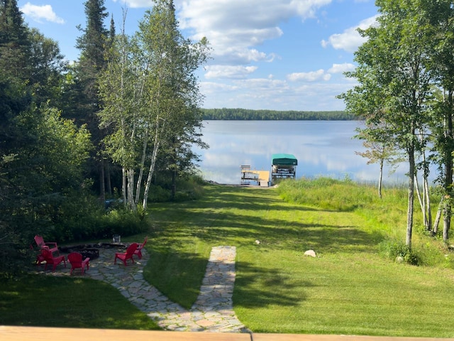 view of yard featuring a patio, a water view, a fire pit, and a dock