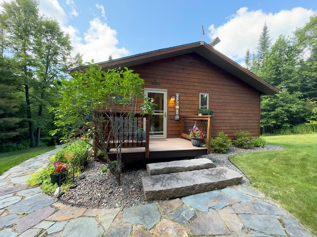 rear view of property featuring a wooden deck and a yard
