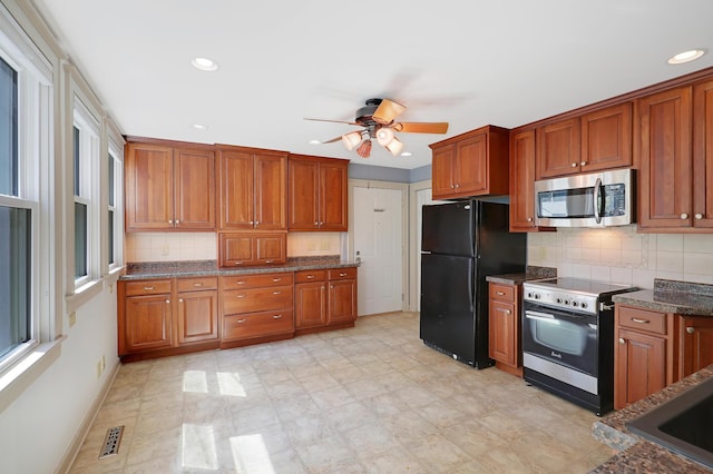 kitchen featuring backsplash, electric range oven, ceiling fan, and black fridge