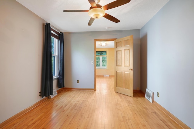 empty room with light hardwood / wood-style flooring and ceiling fan