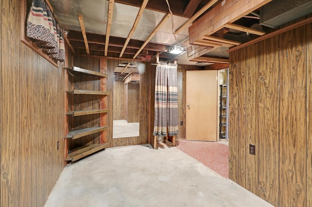 basement featuring wooden walls