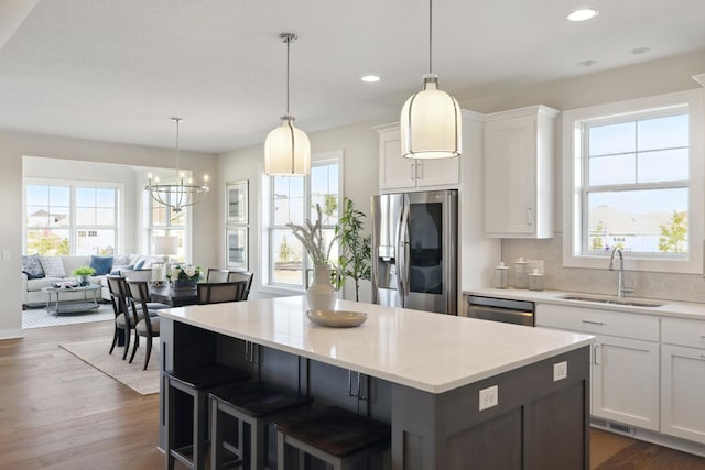 kitchen featuring white cabinetry, sink, pendant lighting, and stainless steel appliances