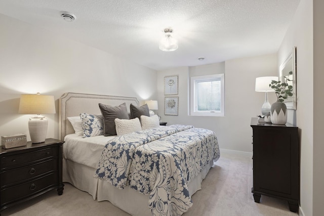 bedroom featuring light colored carpet and a textured ceiling