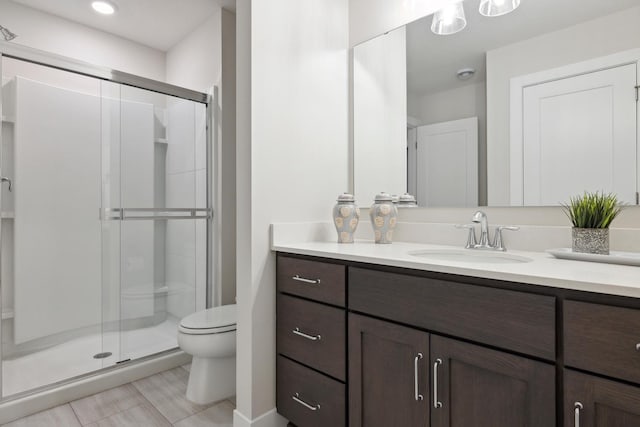 bathroom with vanity, an enclosed shower, and toilet