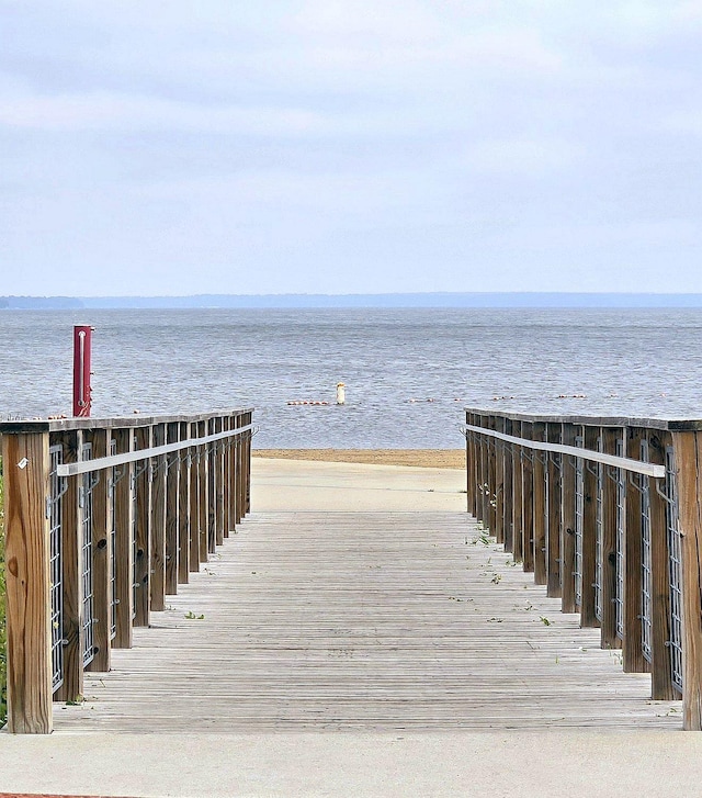 view of home's community with a water view and a beach view