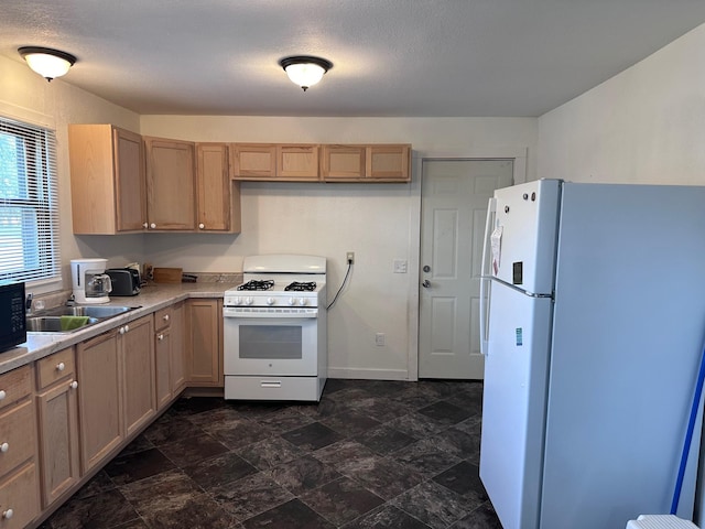 kitchen featuring sink, white appliances, and a textured ceiling