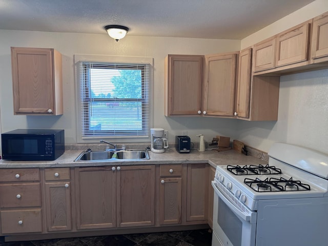 kitchen with white gas range, sink, and a textured ceiling