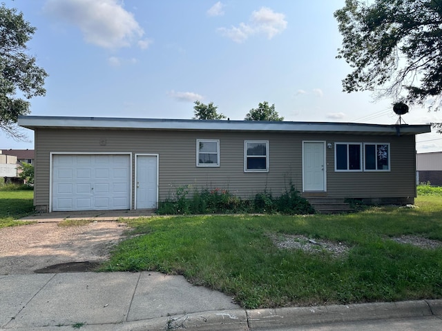 ranch-style home with a garage and a front lawn