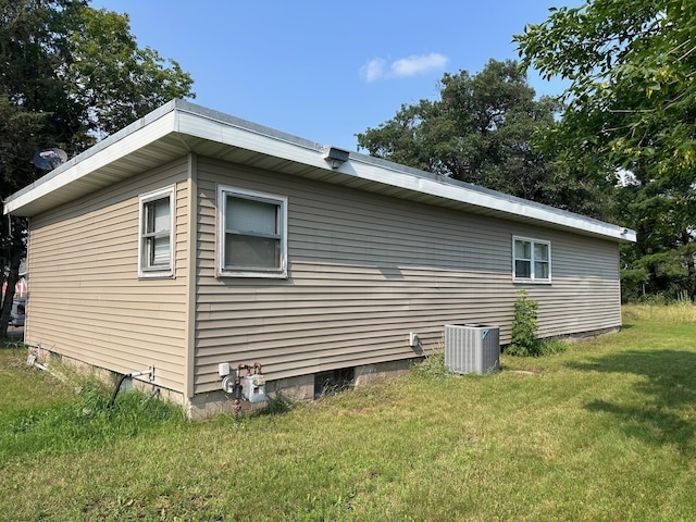 view of property exterior with a lawn and central air condition unit