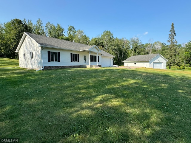 ranch-style house with a front yard, a garage, and an outbuilding