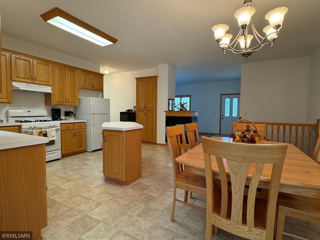 kitchen featuring pendant lighting, white appliances, a chandelier, and a center island