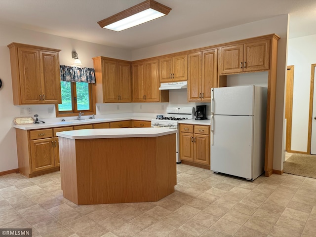 kitchen featuring sink, white appliances, and a center island