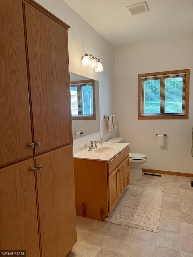 bathroom with vanity, tile patterned flooring, and toilet