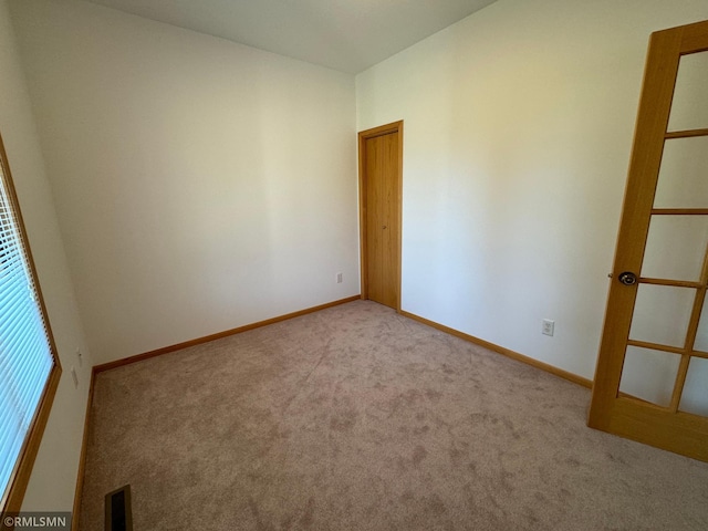 unfurnished room featuring light colored carpet