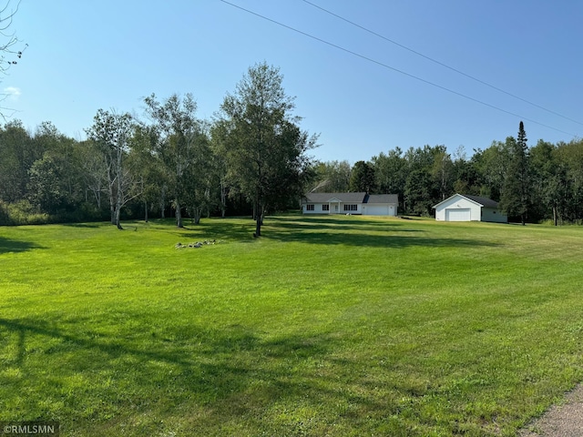 view of yard featuring a garage and an outdoor structure