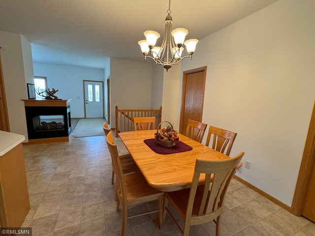 dining room with a notable chandelier and a multi sided fireplace