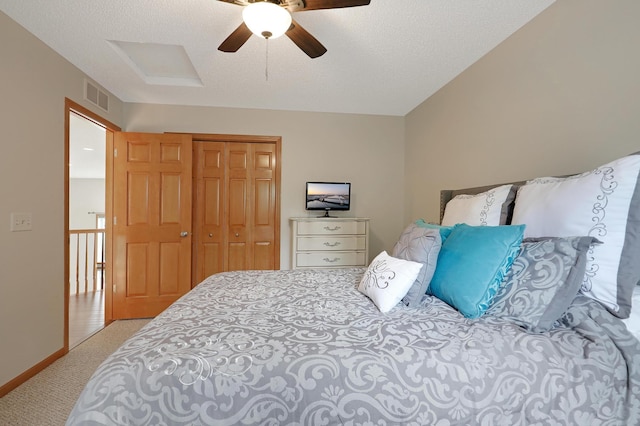 carpeted bedroom featuring ceiling fan, a textured ceiling, and a closet