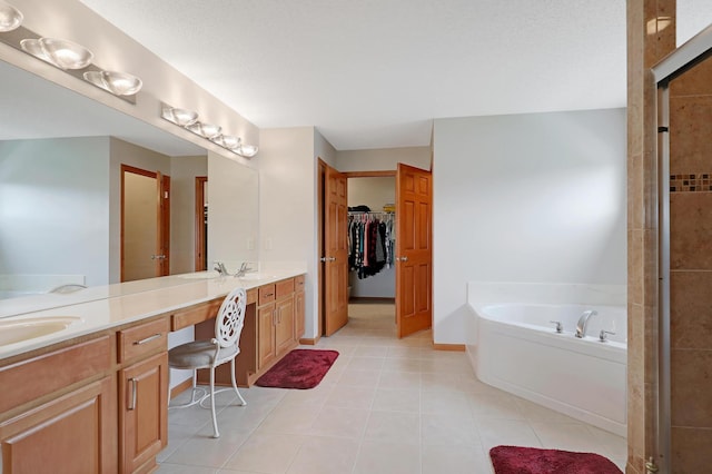 bathroom with vanity, tile patterned flooring, and a bath