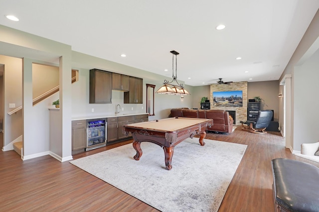 rec room with wine cooler, wet bar, pool table, a fireplace, and hardwood / wood-style floors