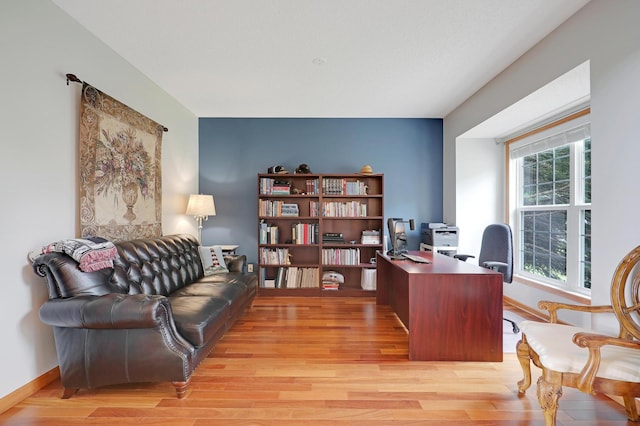 home office with light hardwood / wood-style flooring