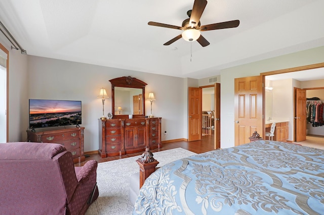 bedroom with a closet, ceiling fan, a walk in closet, and hardwood / wood-style flooring