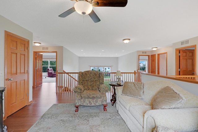 living room with wood-type flooring and ceiling fan