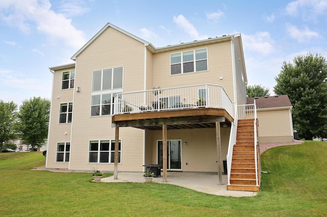 rear view of property featuring a deck, a lawn, and a patio area