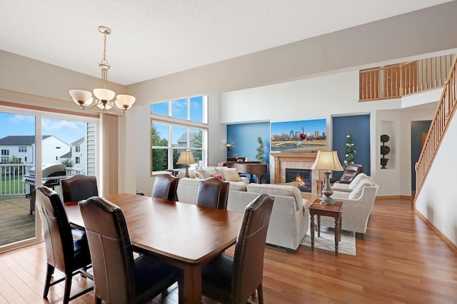 dining space with wood-type flooring, an inviting chandelier, and a healthy amount of sunlight