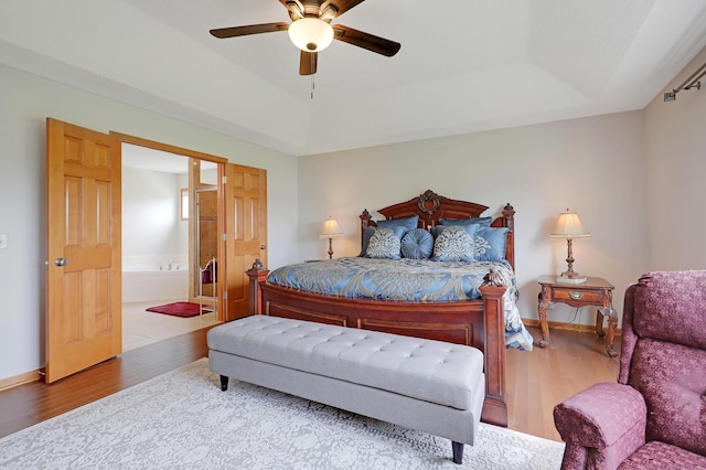 bedroom featuring wood-type flooring, connected bathroom, and ceiling fan