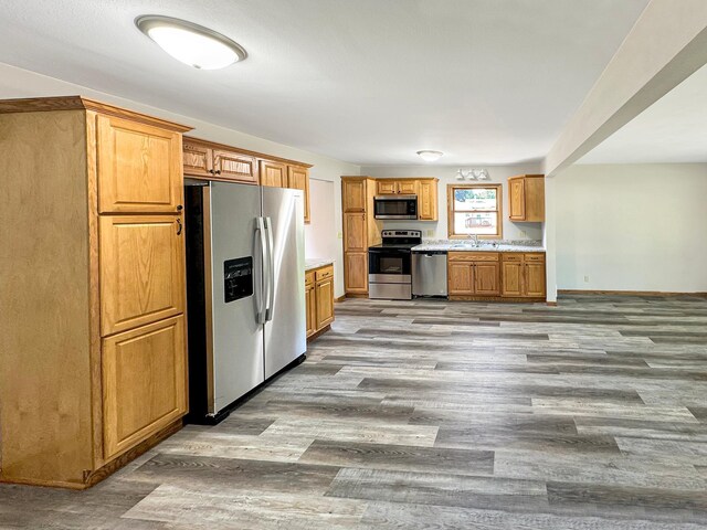 kitchen featuring light hardwood / wood-style flooring, appliances with stainless steel finishes, and sink