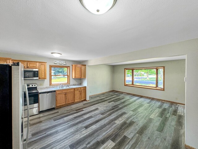 kitchen with stainless steel appliances, hardwood / wood-style floors, sink, and a textured ceiling