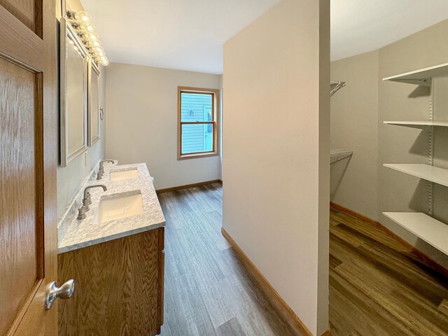 bathroom with hardwood / wood-style flooring and double sink vanity