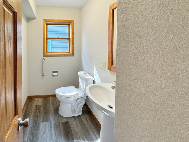 bathroom featuring wood-type flooring and toilet