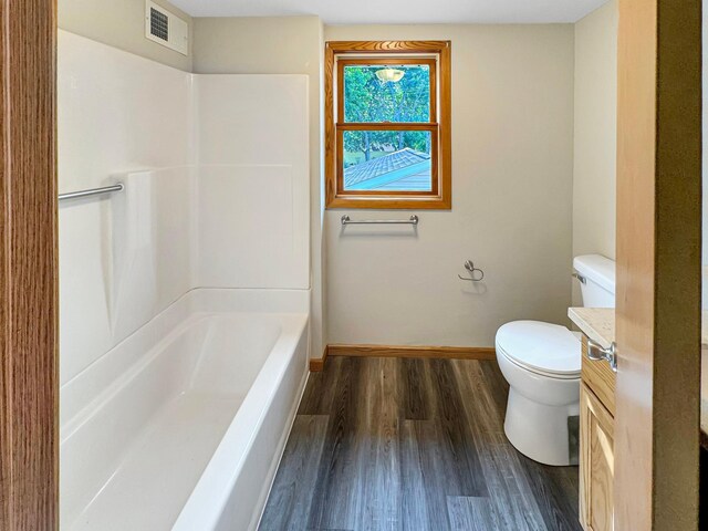 full bathroom with vanity, hardwood / wood-style flooring, shower / bathing tub combination, and toilet