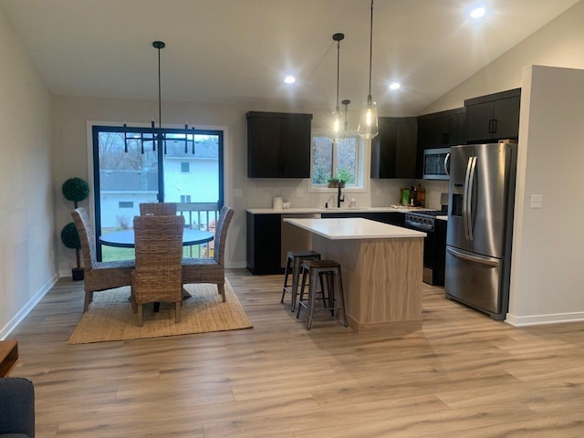 kitchen featuring light wood-type flooring, a center island, stainless steel appliances, and plenty of natural light