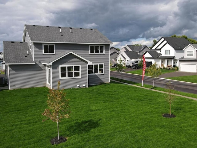 back of property featuring a yard, central air condition unit, and a garage