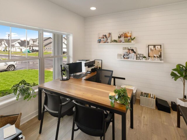 office area with light wood-style flooring, recessed lighting, a residential view, and wooden walls
